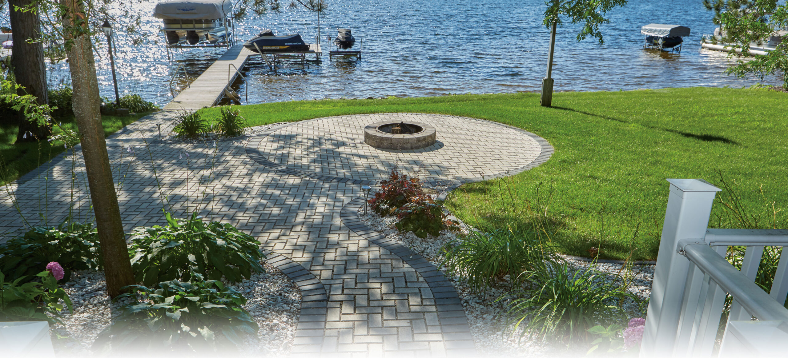 lake landscaping project with fire pit and pavers