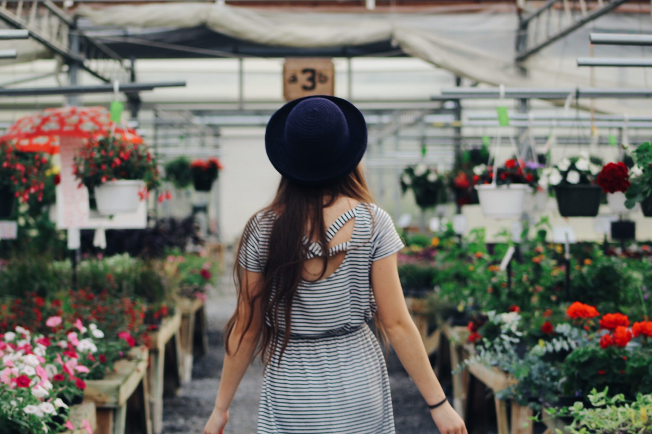 Woman walking through flower shop greenhouse